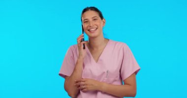 Konuşan doktor, mutlu ve telefonda konuşan bir kadın stüdyoda mavi bir arka planda izole edilmiş. Danışmanlık, iletişim ve sağlık personeli hemşirelik ve tıbbi danışmanlık için cep telefonundan konuşuyor..