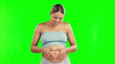 Hamilelik, yeşil ekran ve hamile bir kadının bebeğe bakması ve karnına dokunması. Sağlık, şekil ve genç kadın. Çocuk bakımı, destek ve gelecek için ellerini göbeğine koy..