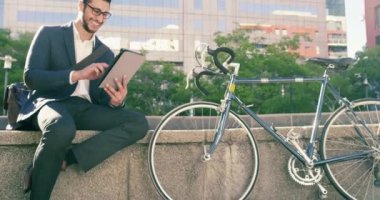 Tablet, şehir ve mutlu adam iş projesi, araştırma bilgileri ve online şirket raporu üzerinde çalışıyor. Kentsel ulaşım bisikleti, çevre dostu bisiklet ve teknolojiyi kullanan insanları rahatlatmak..