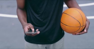 Basketbol sahasında spor, sağlık ya da oyunlar için yazma, yazma ve iletişim kurma ile telefon ve mesajlaşma. Spor için kişi, akıllı telefon ve top, çalışma veya eğitim sosyal medyaya tıklanarak.