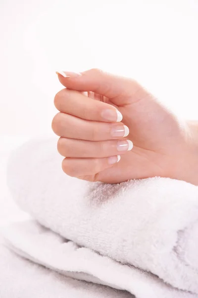 Woman, hand and french manicure for nails, polish and cosmetic care, skincare and beauty. Natural growth, wellness and treatment for hygiene, closeup and towel for girl, maintenance and parlour.