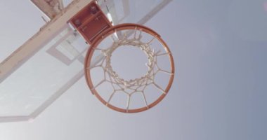 Basketbol, net ve aşağıdaki sahada ya da açık hava parkında maç için mavi gökyüzü, basket ya da skor puanı. Basket yüzüğü, delik ya da top arka tahtası yakın skor ya da hedef dışı gol için atlıyor.