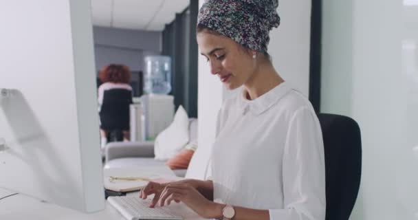 会計代理店で考え またはソリューションを備えたビジネス女性 タイピング コンピュータ キーボード または職場での財務レビューをクリックするムスリムの人 従業員 — ストック動画