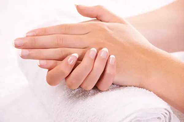 Woman, hands and french manicure in spa, salon and cosmetic care, skincare and beauty. Natural tips, wellness and treatment for hygiene, closeup and nail parlour with towel, clean and maintenance.