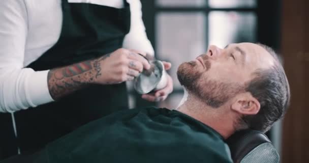 理发店人员 护肤霜和客户切割面部整容 保养或理发 理发师设备 客户和理发师用刷子刷剃须霜的应用 — 图库视频影像