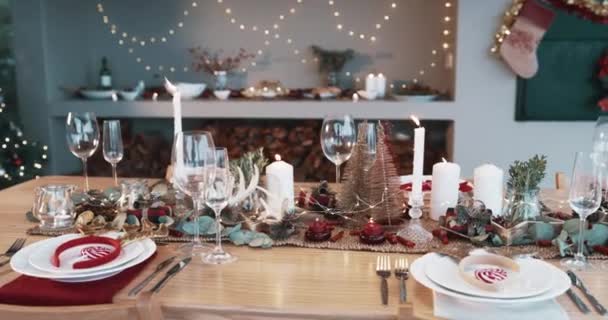 圣诞装饰 客厅里的烛光晚餐 晚餐和带有乡村美学色彩的庆祝活动 圣诞晚会 小型树木和室内活动的烛光下的盘子 布景和餐巾 — 图库视频影像