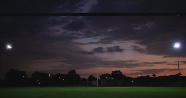 橄榄球场 夜间和草地的运动场与灯光和体育馆健身的位置在城市 与职业和运动员一起参加训练俱乐部的场地 场地和锻炼 以进行训练和发展 — 图库视频影像