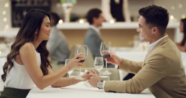 Akşam yemeğinde evlilik yıldönümü kutlaması için restoranda el ele tutuşan, kadeh kaldıran ya da mutlu bir çift. Şerefe, romantik erkek ya da kadın. Sevgililer gününde güzel yemekler, muhabbet ya da şarap içmek..