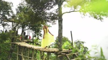 Seyahat, orman ve dağ, Vietnam 'da lüks bir tatil için köprüdeki kadın. Özgürlük, macera ve bayram modasında yürüyen kız tropikal ormanlarda ağaçlarla, bulutlarla ve Asya 'da seyahat.