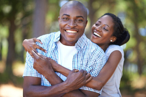 Hug, portrait or happy black couple in forest to relax or bond on holiday vacation together in nature. Hiking, travel or African woman with smile or man in woods trekking on outdoor park adventure.
