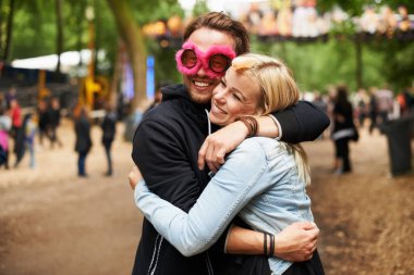 Mutlu çift, kalabalık bir partide, DJ etkinliğinde ya da müzik parkında sevgi, ilgi ya da destek için kucaklaşma ve açık hava festivali. Erkek ve kadın kucaklaşarak gülümser, sevgi ya da güven şenlikli bir kutlama ya da yaz tatili için.