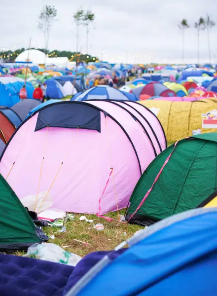 Tents, campsite and music festival on outdoor field or mess pollution, garbage from party crowd. Shelter, group and entertainment dance gathering event or waste land for holiday, dirt in environment.