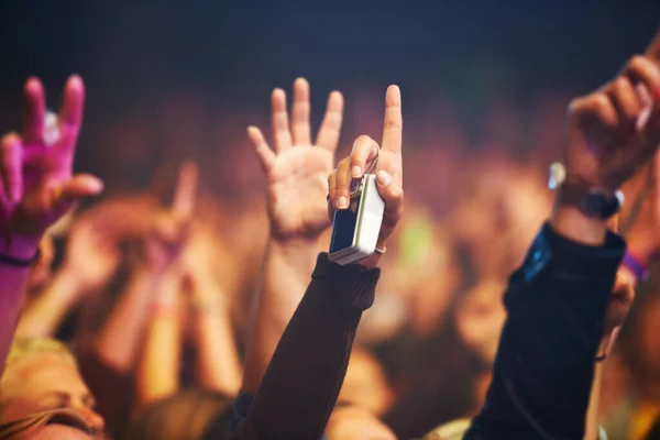 Hands, camera and a crowd of people at a music festival closeup with energy for freedom or celebration. Party, concert or event with an audience at a rock or musical performance or nightlife show.