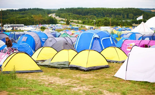Tents, field and music festival outdoor for dancing event in forest for party celebration, rave weekend on vacation. Campsite, land and crowd for concert dj disco accommodation, park trip in nature.