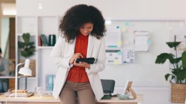 Cheerful, smiling and happy black business woman browsing on a digital tablet in a modern office. Portrait of confident entrepreneur feeling ambitious and motivated for success while planning online.