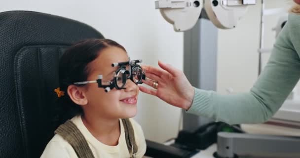 眼科检查 验光和配眼镜 并配备女童眼架 用于视力 视力和眼镜的儿童眼科检查 诊所的保健 医疗设备和与妇女一起使用处方晶状体的年轻病人 — 图库视频影像