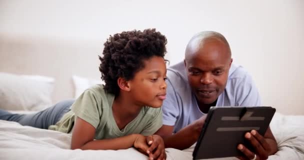 ベッドルームのタブレットの父 黒人の子供 学習や漫画を一緒に見る アフリカの子供たち テクノロジーと父親 ベッドで インターネット上のウェブサイトアプリや家族 自宅のソーシャルメディアでリラックスしたり絆を結ぶ — ストック動画