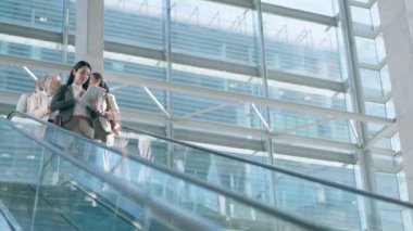 Yürüyen merdivenler, teknoloji ve iş adamları işe gidip gelmek için ofiste. Şirket çalışanları, profesyonel ve kadın işçiler kariyer, iş ve seyahat için modern işyerinde asansörde.