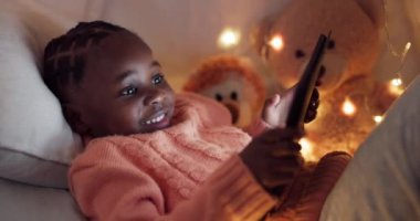 Kız, tablet ve çocuk gece yatak odasında online, mobil uygulama ya da internet, web sitesi ya da sosyal medya ile oynuyor. Afrikalı çocuk, evde teknolojiyle rahatlamak için oyun oynuyor ve arıyor..