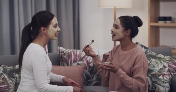 家庭のリビングルームの友人 フェイシャルマスクは 会話の中で結びつき 幸せです ソファーの女の子 笑顔と美容化粧品 リラックスして顔のスキンケア メイクとブラシを適用 — ストック動画