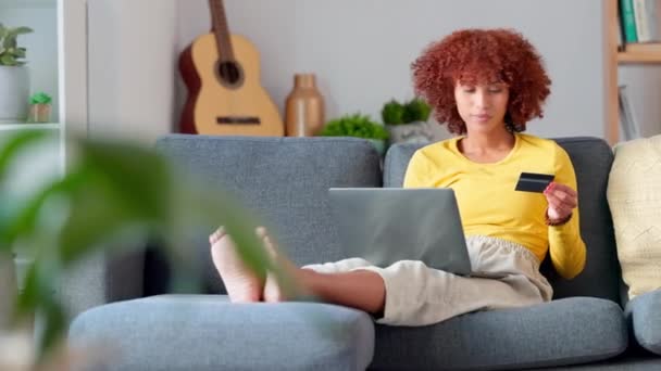 兴奋的女人用信用卡在网上购物 女性坐在沙发预算上 花钱买了一辈子的生意 快乐的微笑的女孩买了一个新的舒适温暖的配件 — 图库视频影像