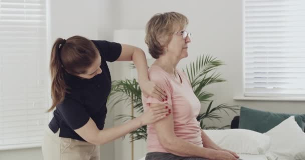 Старшая Женщина Физиотерапевт Массаж Рук Реабилитации Физиотерапии Пациентка Разговаривает Хиропрактиком — стоковое видео