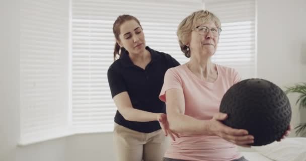女性患者 理疗师和药物球运动 用于康复和理疗 有脊医的老年人 负责理疗锻炼 健康和保健 — 图库视频影像