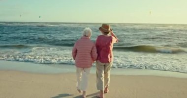 Kıdemli kadınlar, arkadaşlar ve kumsalda el ele tutuşup, deniz yoluyla yeniden bir araya geliyorlar. Yaşlı bayan, insanlar ve tropikal dalgalar, okyanus ve özgürlük ile tatil, yürüyüş ve emeklilik.
