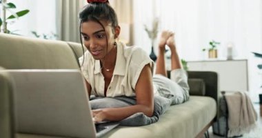 Dizüstü bilgisayar, kadın ve evdeki kanepede daktilo, uzaktan çalışma ve oturma odasında araştırma. Hintli kadın kişi, döşeme ve serbest yazı veya kontrol e-posta, sosyal medya ve ağ.