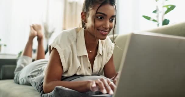 印度女性 笔记本电脑或社交媒体可以在沙发上轻松地在博客 网站或电子邮件上打字 远程工作或快乐的人 带着微笑或科技在家里客厅的沙发上工作 — 图库视频影像
