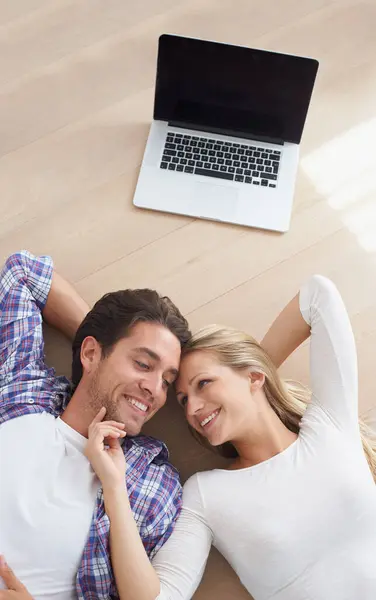Happy couple, touch and living room floor with laptop, marriage and relax for love, home and tech. Wife, husband and smile for commitment, bonding together and care for relationship, man or woman.