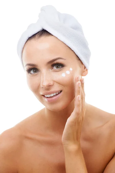 Stock image Portrait of model, white background or face cream for skincare, beauty or cosmetics in studio. Apply, towel or female person with product, wellness or glow for lotion, dermatology or facial treatment.