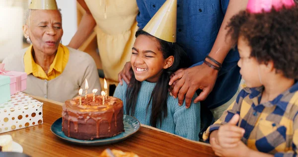 Happy family, birthday and cake in celebration for party, holiday or special day together at home. Excited little girl or child smile in growth, love or care for event, bonding and wish with candles.