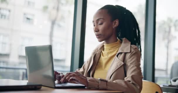 严重的黑人妇女在咖啡店的笔记本电脑上打字 远程工作和阅读电子邮件的互联网 网络或搜索 咖啡店 商店或餐馆的计算机 自由撰稿人和撰稿人 撰写博客或文章 — 图库视频影像