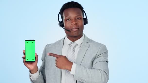 呼叫中心 男人的脸和手指向工作室的绿色屏幕电话 以签署蓝色背景的信息 电话营销 智能手机和咨询师的肖像展示与我们联系 平台或服务 — 图库视频影像