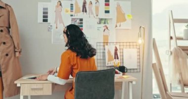 Moda tasarımcısı, ofis masası ve planlama, yaratıcı fikirler ve ilham için kartondan üretim. Başlangıçta giysi ve tekstil için belgeleri olan kadın, terzi veya sanatçı.