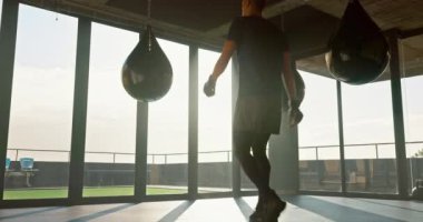 Boks, fitness ve spor, sağlık ve spor için spor salonunda kum torbası taşıyan bir adam. Mma, meydan okuma ve atlet boksör kardiyo çalışması yapıyor veya güçlü vücut ve mücadele için egzersiz yapıyor.