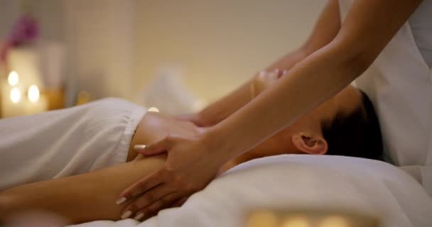 护肤和女人按摩在温泉禅 理疗在床上与蜡烛在度假胜地 在沙龙休息 照顾身体或休息以获得健康和健康的平静女性的脸 — 图库视频影像