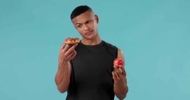健康のためのスタジオで男性の顔とApple ドーナツと選択 シュガー 食べ物 デトックス 青い背景の人の肖像画と果物 意思決定 オプション — ストック動画