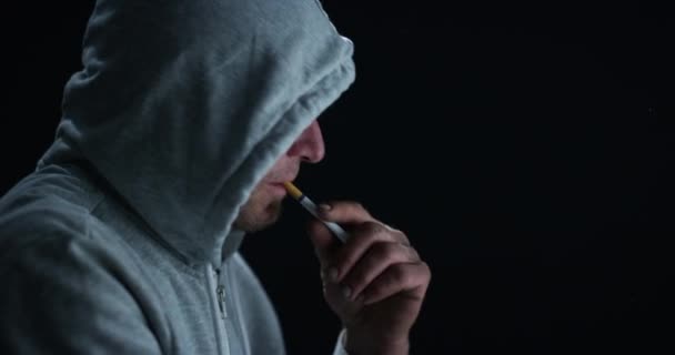 吸烟和打火机在黑暗的背景下轮廓思考 压力或恶习在帽衫 因焦虑 思想或夜间火焰而使用烟草制品的男人 瘾君子和心理健康 — 图库视频影像