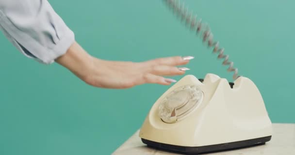 スタジオ レトロな電話 幸せなボタン 緑色の背景で数字をダイヤルするボタン クローズアップ 少女やロータリー電話を持つ人 ヴィンテージ技術との話し合いとコミュニケーション — ストック動画
