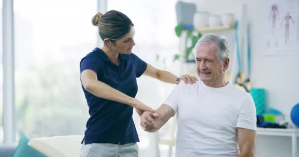 理学療法士 シニアマン 腕を伸ばす 関節炎を癒す または筋肉のリハビリテーション 関節痛またはけがの評価 高齢者を支援する生理療法 医療支援 カイロプラクター — ストック動画