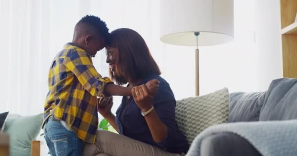 男孩和快乐在沙发上的额头接触与微笑 粘合或关心在家里有趣的对话 非洲妈妈 手牵手拥抱 在黑人家庭的房子里聊天或玩游戏 — 图库视频影像