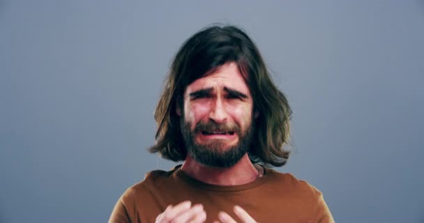 悲しみ 悲しみ 若い男性は うつ病の表情でスタジオで泣いています 悪いニュース 灰色の背景によって隔離された壊れた心の涙を持つオーストラリアの男性 — ストック動画