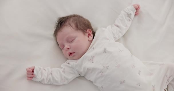 かわいい 眠っている そして生まれたばかりの赤ん坊は 寝室の家で休んで夢を見ている 家族の家で保育園で午前中に昼寝をする赤ちゃん または子供の疲れた トップビュー — ストック動画