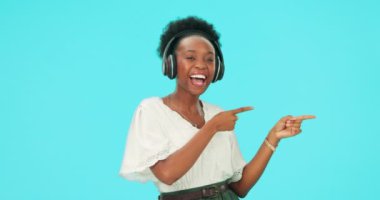 İşaret, müzik ve kulaklıklı siyah kadın, stüdyoda mutlu ve dans, mavi arka planda izole edilmiş bir şekilde. Radyo, yayın ve kişi tanıtım, reklam ve yüz portresi.
