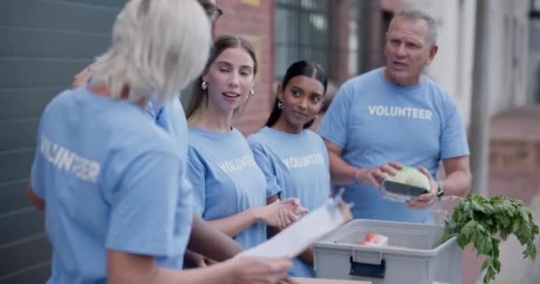 Vrijwilligerswerk Groep Praten Donatie Mensen Uitpakken Kruidenierswaren Voedsel Pakket Groenten — Stockvideo