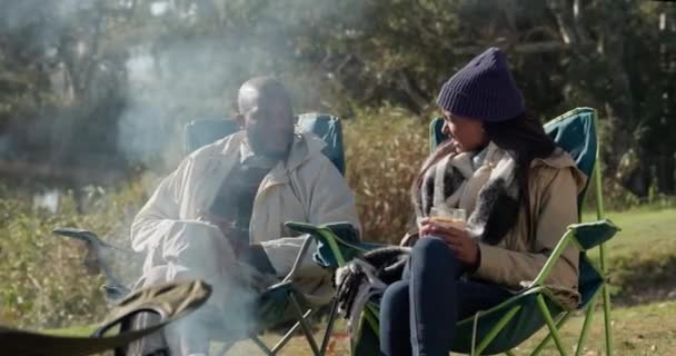 在户外度假 度假或周末休息时 大自然 野营或篝火边的情侣可以放松一下 作为露营者 坐在椅子上聊天 说话或享受谈话的黑人男女 — 图库视频影像