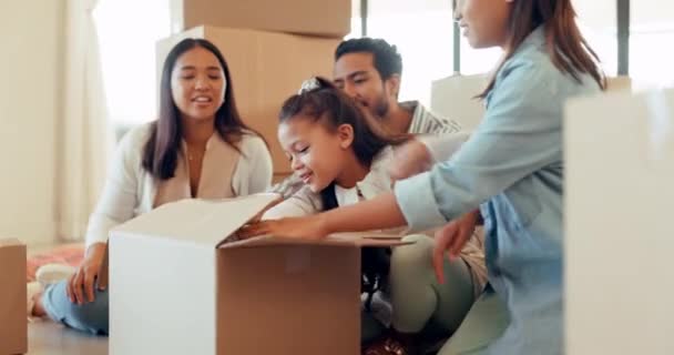 stock video Happy people, moving and unpacking boxes with new home and property, young girl hug soft teddy bear and happiness. Family is excited, mortgage and real estate, parents with female children and toys.