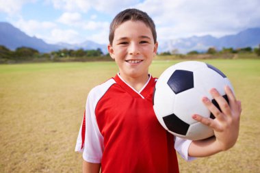 Çocuk, portre ve futbolcu sahada, spor ve maç ve oyun için güven. Mutlu çocuk, yüzleş ve açık havada yarışmaya hazır ol, gülümse ve çalış ya da çimenlerdeki beceriler için çalış..